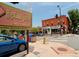 Street scene at Highlands Square with various businesses, signage, and a blue car in view at 2975 Irving St, Denver, CO 80211