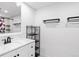 Bathroom featuring white vanity, sleek mirror, and modern fixtures and towel racks at 3546 S Depew St # 103, Denver, CO 80235