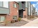 Close up of condo building showing stairs, brickwork, and well-maintained landscaping at 3546 S Depew St # 103, Denver, CO 80235