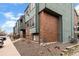View of condo building exterior featuring brickwork, outdoor stairwells, and a well-kept lawn at 3546 S Depew St # 103, Denver, CO 80235