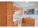 Bright kitchen features wood cabinets, white countertops and standard white appliances at 3546 S Depew St # 103, Denver, CO 80235