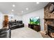 Cozy living room featuring a stone fireplace and comfortable black leather seating at 3546 S Depew St # 103, Denver, CO 80235