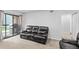 Living area includes a modern sofa, sliding glass door, and neutral carpet at 3546 S Depew St # 103, Denver, CO 80235