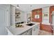 Bright kitchen boasts a white quartz countertop, a brick wall accent, and stainless steel appliances at 4036 Navajo St, Denver, CO 80211