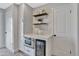 Kitchen area features white cabinets, stainless microwave, wine cooler, and stylish shelving decor at 4036 Navajo St, Denver, CO 80211