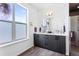Bright bathroom with dual sink vanity, large window, and frameless glass shower at 4950 Lowell Blvd, Denver, CO 80221