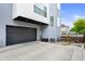 View of the house's exterior showcasing a modern dark gray garage, concrete driveway, and architectural details at 4950 Lowell Blvd, Denver, CO 80221