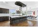 Bright kitchen featuring an island with counter seating, modern appliances, and sleek cabinets and view to dining area at 4950 Lowell Blvd, Denver, CO 80221