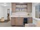 Basement bar with custom cabinets, open shelving and beverage cooler at 2107 S Grant St, Denver, CO 80210