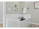 Clean bathroom featuring a built-in tub with white tile surround, matte black fixtures, and decorative wall art at 2107 S Grant St, Denver, CO 80210