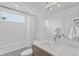 Bright bathroom features a shower-tub combo, white tile, and contemporary fixtures, providing a fresh, clean space at 2107 S Grant St, Denver, CO 80210