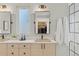 Stylish bathroom features a double vanity, framed mirrors, and modern fixtures, along with a walk-in closet view at 2107 S Grant St, Denver, CO 80210