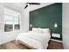 Bright bedroom featuring a modern ceiling fan, a large window and a stylish green accent wall at 2107 S Grant St, Denver, CO 80210