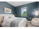 Calming bedroom with blue walls, natural light, and a cozy sitting area, perfect for relaxation at 2107 S Grant St, Denver, CO 80210