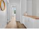 Bright hallway with wood floors, a modern cabinet, and access to various rooms at 2107 S Grant St, Denver, CO 80210