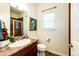 A half bathroom shows a sink with a granite countertop, shower, toilet, and artwork at 575 Heritage Trl, Elizabeth, CO 80107