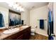 A bathroom with double sinks, granite counters, a large mirror, and a shower-tub combo is displayed at 575 Heritage Trl, Elizabeth, CO 80107