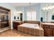 The bathroom features a deep soaking tub, separate shower, and dual sinks with dark wood cabinetry at 575 Heritage Trl, Elizabeth, CO 80107