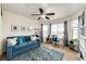 This carpeted bedroom offers a sofa, desk, and bookcase; natural light from the three windows brightens the space at 575 Heritage Trl, Elizabeth, CO 80107