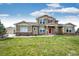Charming two-story home with a well-manicured lawn, complemented by a detached garage and inviting front entrance at 575 Heritage Trl, Elizabeth, CO 80107