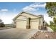 A three-car garage with tan doors and stone accents, offering ample parking and storage at 575 Heritage Trl, Elizabeth, CO 80107
