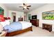 This primary bedroom features carpeted floors, a ceiling fan, dressers, and a flatscreen TV at 575 Heritage Trl, Elizabeth, CO 80107