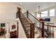 Beautiful staircase with carpeted steps, and iron spindles leading to the upper level at 575 Heritage Trl, Elizabeth, CO 80107