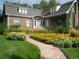 Charming brick home featuring a stone walkway lined with vibrant flower beds at 1788 Glencoe St, Denver, CO 80220