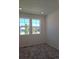 Bedroom with plush grey carpet, with two windows providing natural light, and electrical outlets at 6066 Caribou Dr, Brighton, CO 80601