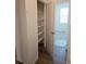 Walk-in closet featuring wood shelving and view of an adjacent bedroom at 6066 Caribou Dr, Brighton, CO 80601