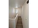 Bright hallway featuring hardwood floors and white walls leading to stairs at 6066 Caribou Dr, Brighton, CO 80601