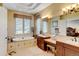 Luxurious bathroom features a soaking tub, double vanity, seated makeup area, and natural light at 9298 Spirit Ct, Parker, CO 80138