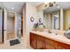 Well-lit bathroom with wood vanity, single sink, neutral tile, and walk in shower at 9298 Spirit Ct, Parker, CO 80138