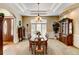 An elegant dining room with a chandelier, neutral carpet, and wainscoting on the walls at 9298 Spirit Ct, Parker, CO 80138
