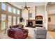 Bright living room with tall windows, cozy fireplace, high ceilings, and comfortable seating area at 9298 Spirit Ct, Parker, CO 80138