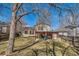 Fenced backyard with an outdoor dining area, grill, and mature shade trees at 13294 W 65Th Dr, Arvada, CO 80004