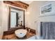 Charming bathroom features wood vanity, vessel sink, decorative mirror, and modern light fixtures at 13294 W 65Th Dr, Arvada, CO 80004