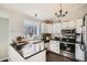 Modern kitchen featuring black countertops, white cabinets, and stainless steel appliances at 13294 W 65Th Dr, Arvada, CO 80004
