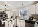 Bright kitchen with a sink overlooking the backyard, skylight and dark wood floors at 13294 W 65Th Dr, Arvada, CO 80004