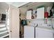 Well-organized laundry area equipped with a washer, dryer, and storage shelving at 13294 W 65Th Dr, Arvada, CO 80004