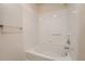 This bathroom features a white tile shower/tub with a sleek silver faucet and bright white walls at 803 E 98Th Ave # 105, Thornton, CO 80229