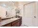 The bathroom features a long vanity mirror and a white door leading to another space at 803 E 98Th Ave # 105, Thornton, CO 80229