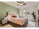 This bedroom features a plush bed, accent wall, ceiling fan, and bright window for natural light at 803 E 98Th Ave # 105, Thornton, CO 80229