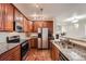 A kitchen showcases stainless steel appliances, dark wood cabinets, granite countertops, and hardwood floors at 803 E 98Th Ave # 105, Thornton, CO 80229