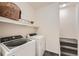 Functional laundry room with modern washer and dryer, shelf and neutral decor for organization at 803 E 98Th Ave # 105, Thornton, CO 80229