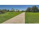Scenic walking path through lush green grass and mature trees, perfect for outdoor recreation at 803 E 98Th Ave # 105, Thornton, CO 80229