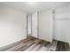 Neutral bedroom with wood-look floors, closet with shelving, and a door to the hallway at 795 S Alton Way # 11C, Denver, CO 80247