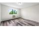 Well-lit bedroom with a window, wood-look floors, and radiator at 795 S Alton Way # 11C, Denver, CO 80247