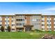 Inviting exterior of a tan and brown apartment building with manicured lawn and charming architectural details at 795 S Alton Way # 11C, Denver, CO 80247