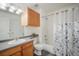 Well-lit bathroom features wood cabinetry and a shower with patterned curtains at 114 Vale St, Palmer Lake, CO 80133